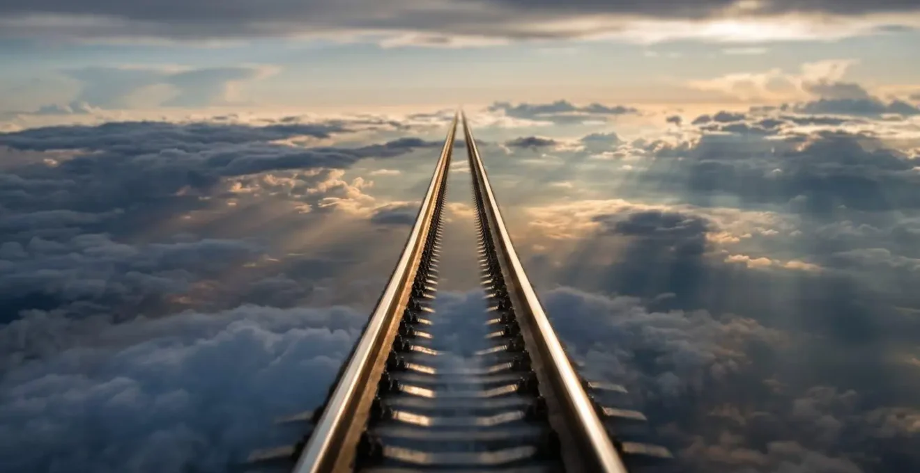 Vue en plongée de rails de train à grande vitesse traversant un paysage de nuages stratifiés, avec lumière dorée créant des reflets sur les rails métalliques brillants, symbolisant l'accélération de la transformation digitale via le cloud